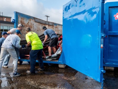 workers loading a dumpster