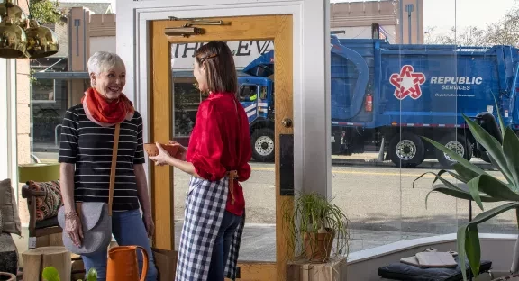 Small retail storefront with Republic Services truck out the window